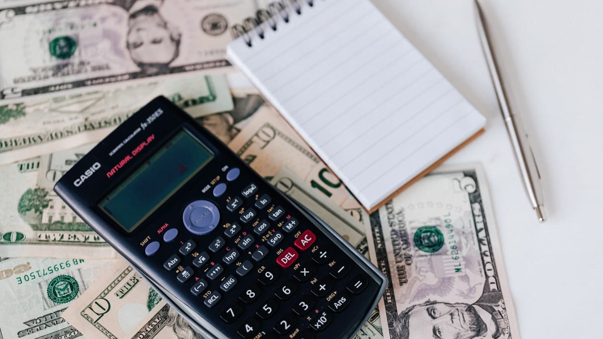 Calculatrice posée sur des billets de banque