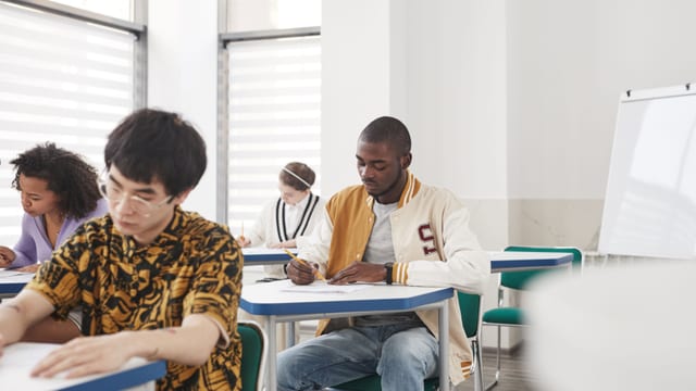 Étudiants passant une épreuve écrite en salle d'examen