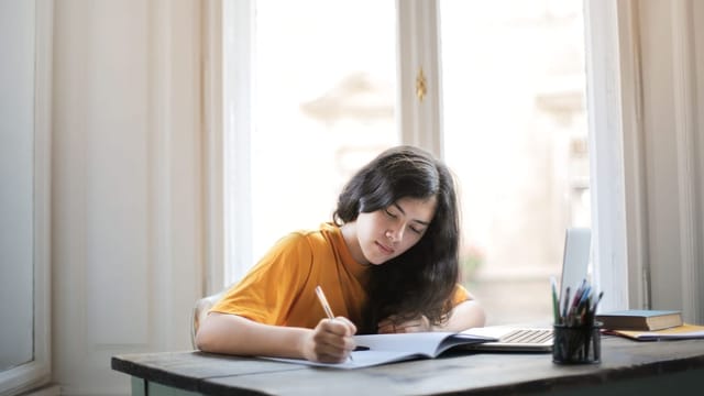 Étudiante rédigeant à son bureau