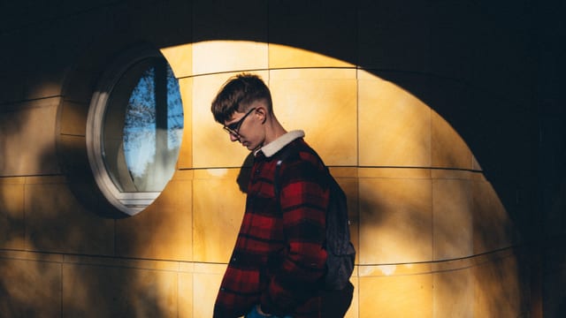 Jeune étudiant songeur regardant par la fenêtre