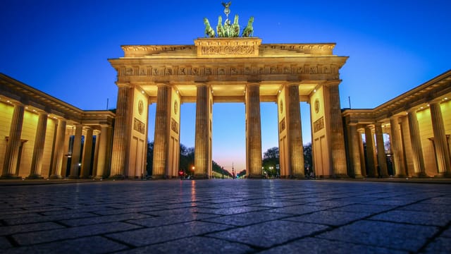 La porte de Brandebourg illuminée à la tombée de la nuit, à Berlin
