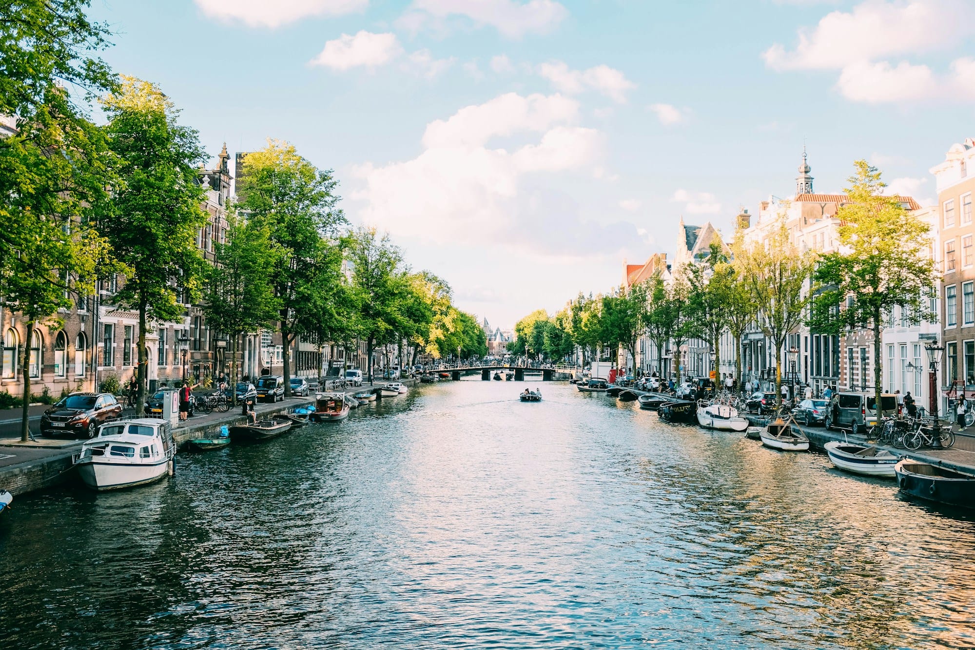 Canal bordé de maisons étroites et de bateaux au centre d'Amsterdam