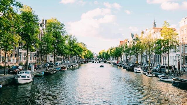 Canal bordé de maisons étroites et de bateaux au centre d'Amsterdam